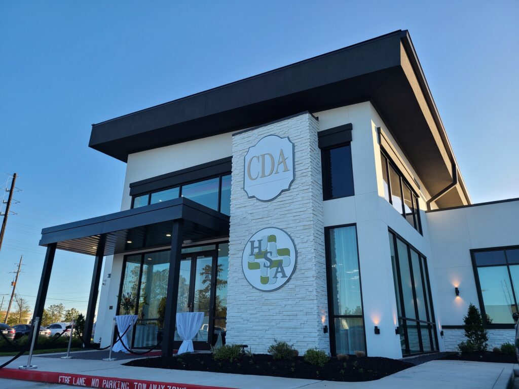 Custom outdoor Houston wall signs on white brick building