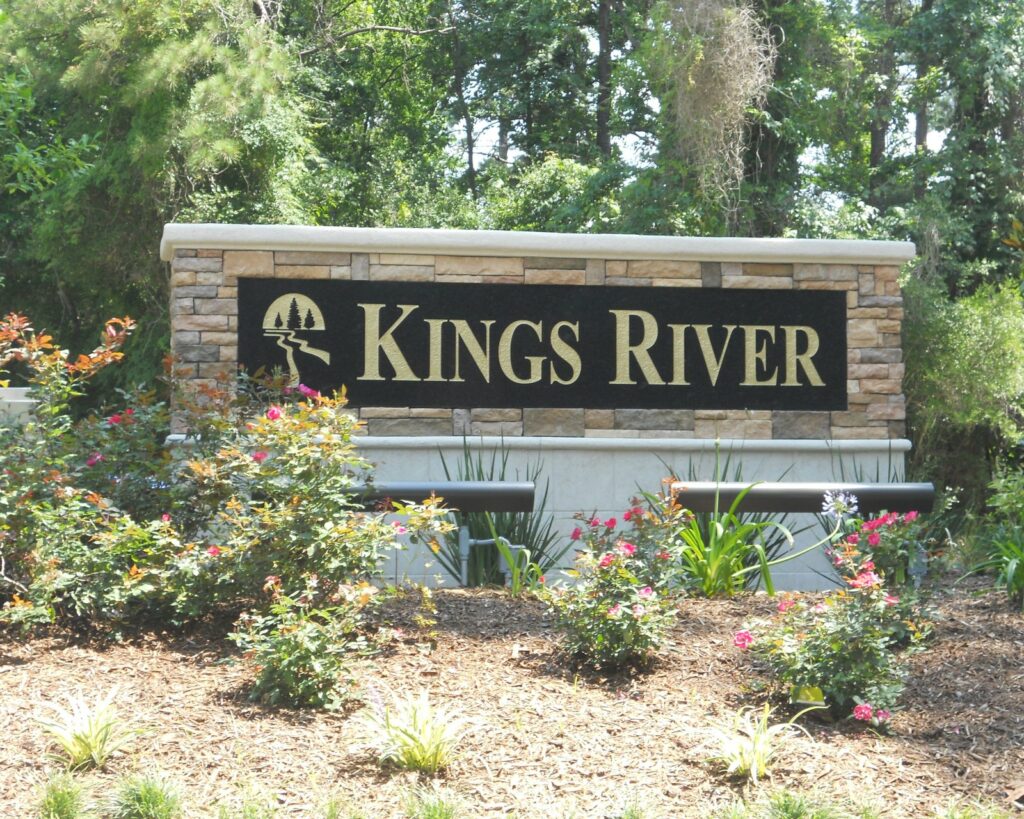 A stone-and-bronze neighborhood entrance monument for Kings River with landscaping, built by 4D SignWorx in Houston