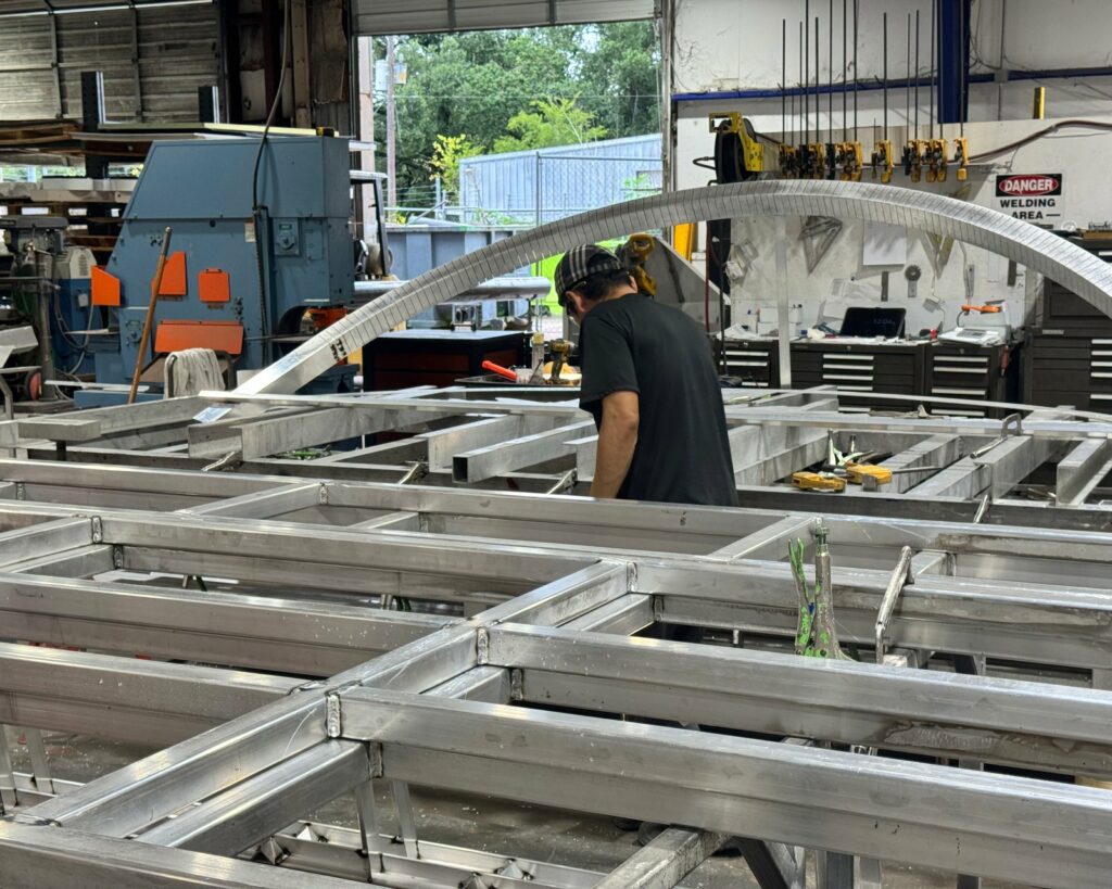 4D SignWorx fabricators welding large aluminum sign structures on the Houston shop floor