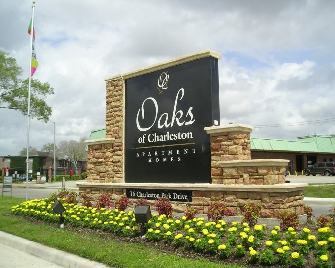 A stone community entrance monument for the Oaks of Charleston with seasonal plantings, built by 4D SignWorx in Houston