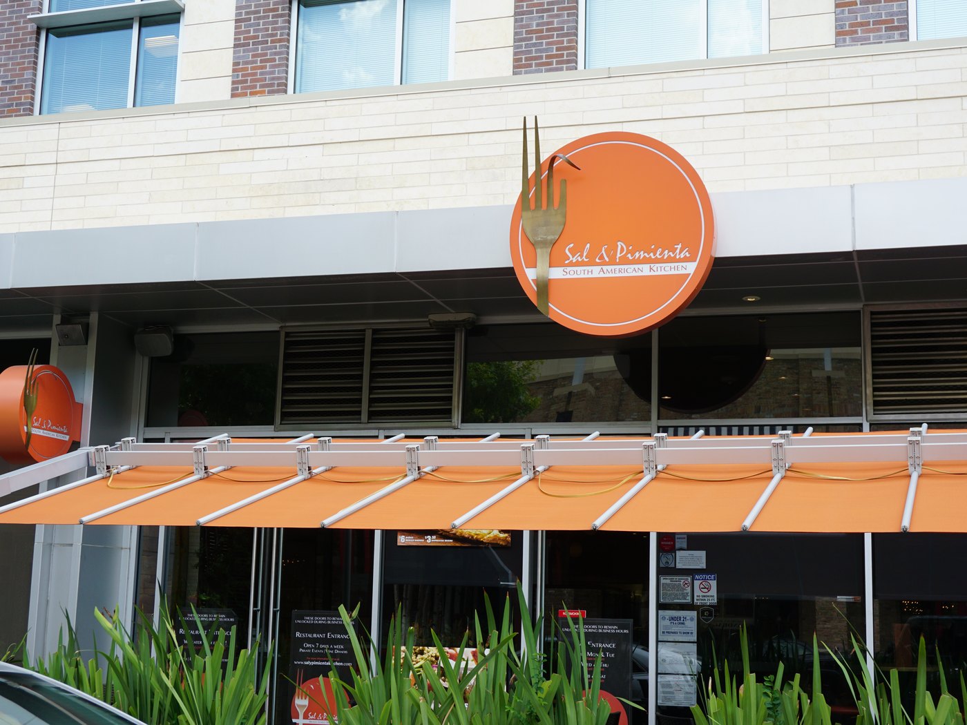 A restaurant storefront with awning and dimensional signage in a Houston retail district, built by 4D SignWorx