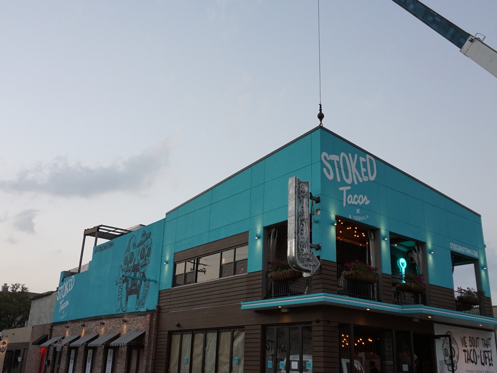 A 4D SignWorx crew installing a storefront sign by crane