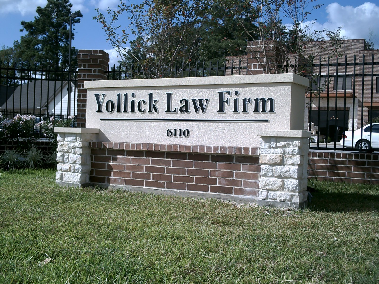 A white professional office monument sign with stone columns, built by 4D SignWorx