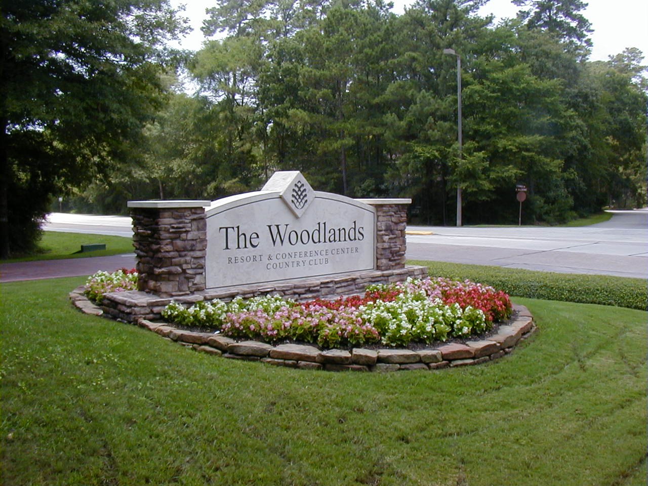 A community marker for The Woodlands in a landscaped roundabout, built by 4D SignWorx