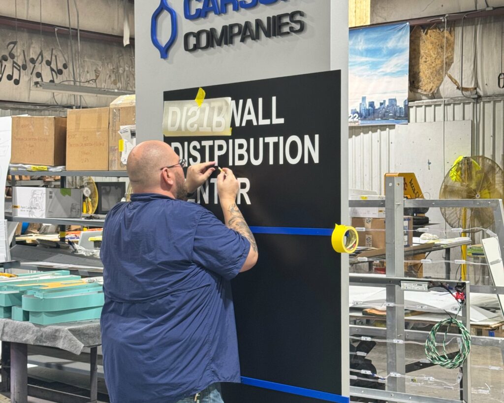 A 4D SignWorx installer fitting a tenant panel to a pylon sign in Houston