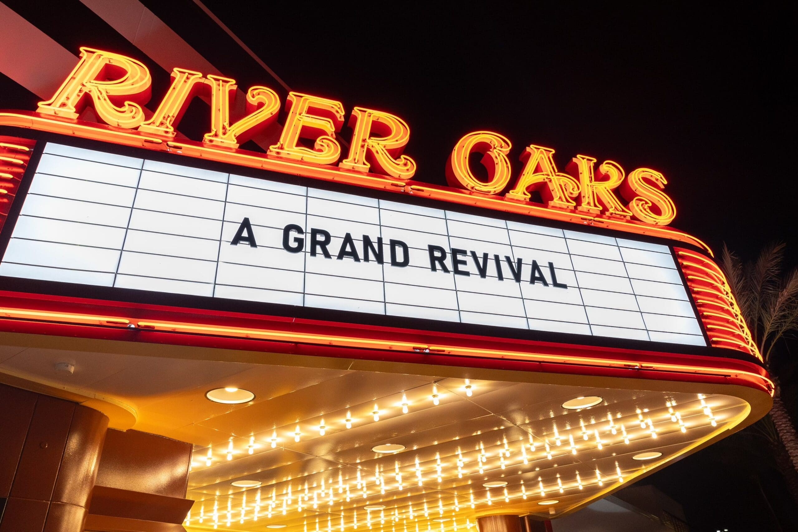 The restored neon marquee at the River Oaks Theatre in Houston lit at night, reading A GRAND REVIVAL